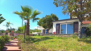 A residential property with a stone pathway, a lawn, and a modern house with large windows and shutters. - Oasis Villa - Villa with pool and private giarino, San Remo (Sanremo)