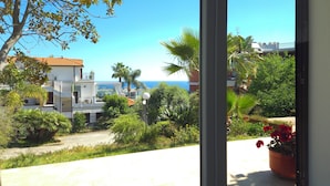 A balcony with a view of a coastal area, including a building with a red roof and a clear blue sky. - Oasis Villa - Villa with pool and private giarino, San Remo (Sanremo)