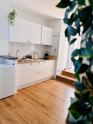 Eine moderne Küche mit weißen Schränken, einer Holz Arbeitsplatte und einem eingebauten Backofen.
