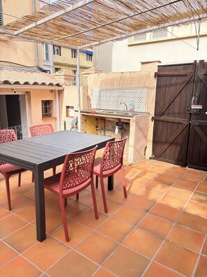 An outdoor patio with a table and chairs, a grill, and a tiled floor. - Marea Cosy Terrace All-Inclusive, Mourillon Center (Toulon)