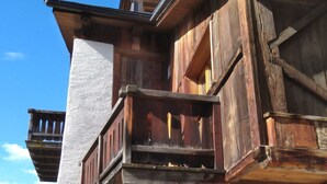 Un bâtiment à deux étages doté d’un balcon en bois, d’une porte en bois et d’un mur extérieur blanc.