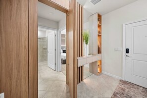 Welcome to a beautifully designed entryway with warm wood accents and soft lighting that sets a cozy tone. The elegant decor features a modern console table with greenery, leading you effortlessly into a stylish bathroom space. - 5BR house with game room, sleeps 14 in clermont (Clermont)