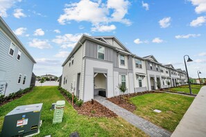 Welcome to a beautifully designed exterior with charming gray siding and white trim, complemented by a bright blue sky. The landscaped yard, featuring neat flower beds and a stone pathway, invites you to enjoy your stay. - 5BR house with game room, sleeps 14 in clermont (Clermont)