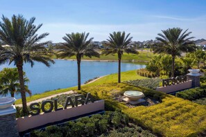 Das Resort Solara mit Seeblick, Palmen und einer gepflegten Rasenfläche.