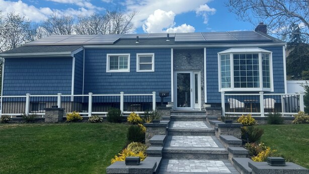 A two-story house with a front porch, a driveway, and a well-maintained lawn.