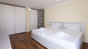 Un dormitorio con una cama doble, un armario y estanterías empotradas.