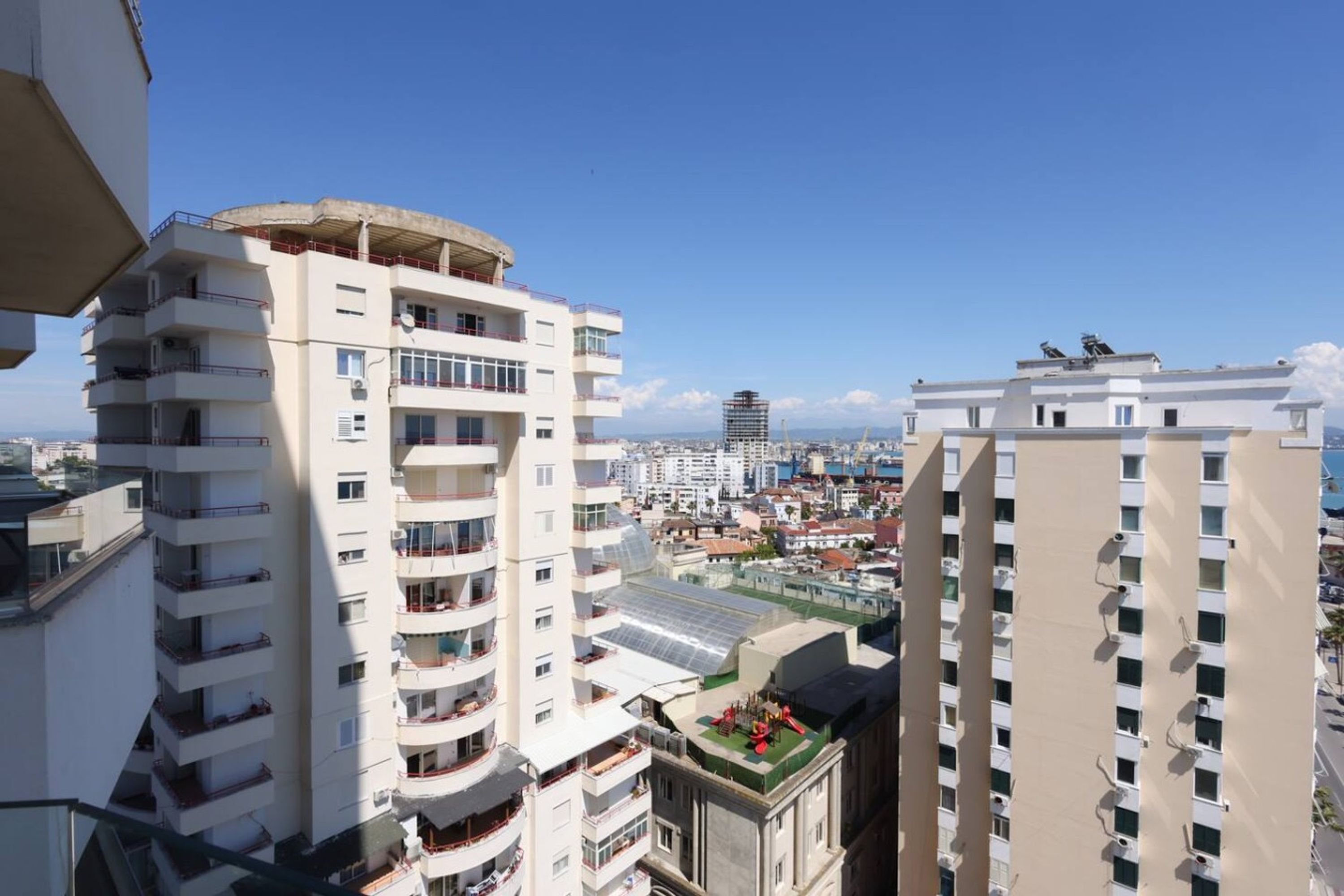 Un edificio alto con numerosi balconi e un giardino sul tetto.