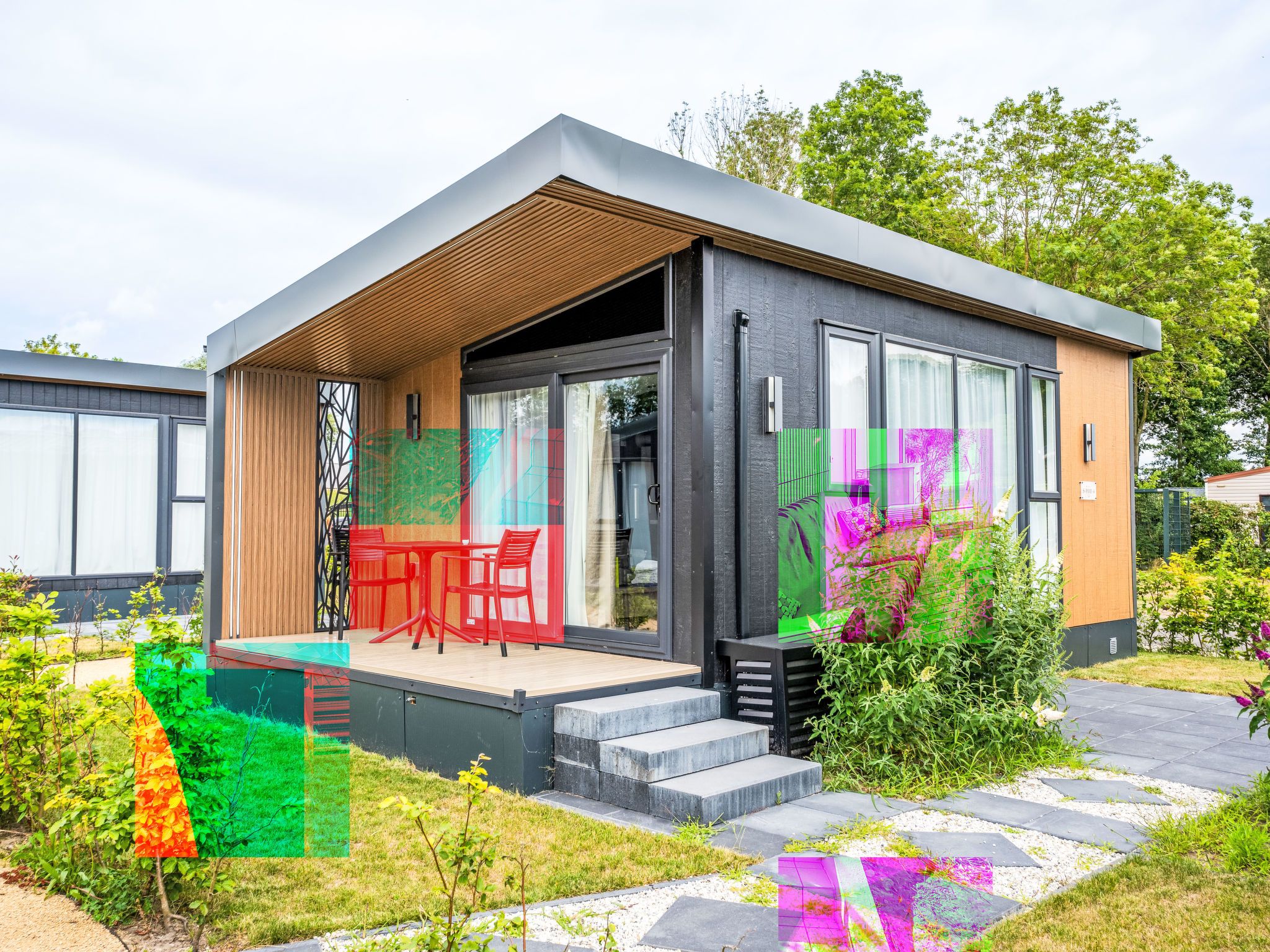 A modern single-story house with a covered patio, large windows, and a garden area.