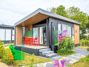 A modern single-story house with a covered patio, large windows, and a garden area.