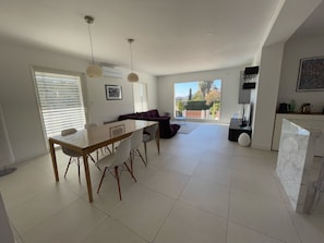 A modern kitchen with a dining area, large windows, and a view of the outdoors. - Contemporary Villa & Pool (Ajaccio)