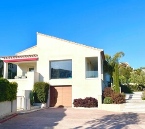 A modern two-story house with a large window, a garage door, and a covered porch. - Contemporary Villa & Pool (Ajaccio)