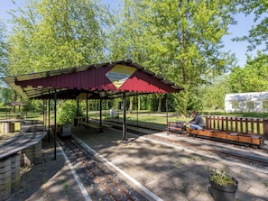 A covered waiting area with benches, a small kiosk, and a sign reading 'Stoomgroep Kerkwerver.' - Tiny Cabin Sunshine no 21 by Interhome (Kerkwerve)