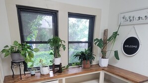 A room with a wooden bench, two windows, and a welcome sign. - Delightful 2-bedroom house in Stephenville just STEPS from Tarleton State (Stephenville)
