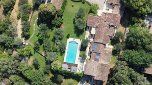 An aerial view of a residential area with a swimming pool, multiple houses, and surrounding greenery. - Villa Bali sur la Côte d'Azur - Oasis among olive trees (Valbonne)