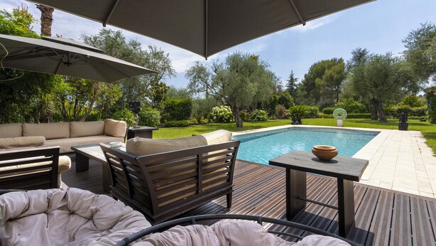 A poolside area with a sofa, chairs, a table, and an umbrella. - Villa Bali sur la Côte d'Azur - Oasis among olive trees (Valbonne)