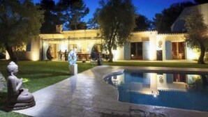 A swimming pool with a curved edge, a statue, and a building with a tiled roof and illuminated windows. - Villa Bali sur la Côte d'Azur - Oasis among olive trees (Valbonne)