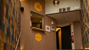 Un escalier menant à un espace d’accueil où est affiché un panneau indiquant : « The Hive ».