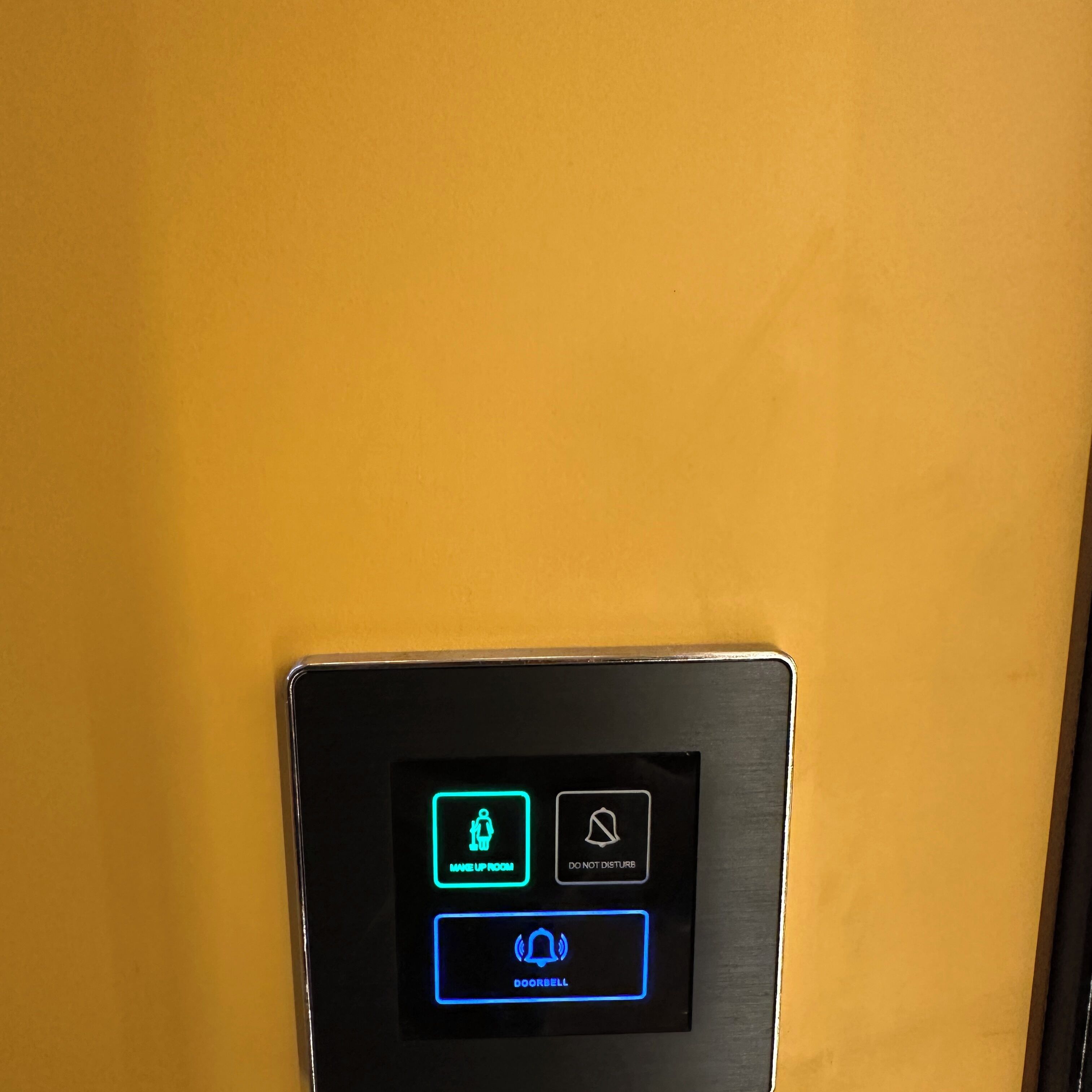 A control panel with illuminated buttons for 'Make Up Room,' 'Do Not Disturb,' and 'Doorbell.'