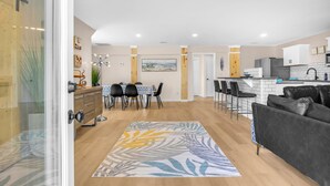 A modern kitchen with white cabinets, a black countertop, and a stainless steel refrigerator. - Stay Salty | Coastal Getaway in Surf City | Dog Friendly (Surf City)