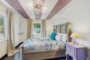 A bedroom with a bed, a nightstand, a lamp, a window with curtains, and a ceiling light fixture. - Elegant Sweet Home Sarasota  (Sarasota)