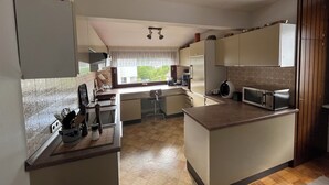 Une cuisine moderne dotée d’un îlot central, d’un four encastré et d’un four à micro-ondes.