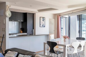 Eine moderne Wohnung mit Küche, Essbereich und einem Balkon mit Blick.