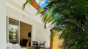 An outdoor patio area with a white sofa, a small table, and chairs. - Studio Ti'Bwa - Terrace 2 pers, 3mn from Anse Mitan beach (Les Trois-Îlets)