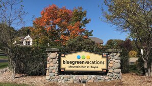 A sign for Bluegreen Vacations at Mountain Run at Boyne with a stone wall and a clear sky. - Enjoy Labor Day weekend in a beautiful 2 BR fully equipped luxury suite. (Boyne Falls)