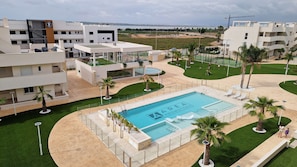 Ein modernes Hotel mit Schwimmbad, mehreren Balkonen und Meerblick.