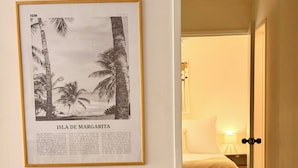 Et indrammet billede af Isla de Margarita, en blå opbevaringskasse og et spiseområde med en stol.
