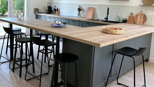 A modern kitchen with a central island, black bar stools, and two wicker pendant lights. - Villa Oïhana 4*, 5 suites, Heated pool, Beach 5 km (Labenne)