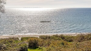 A coastal landscape with a body of water, a distant bridge, and a line of trees. - "Stefan" - 50m from the sea by Interhome (Odder)