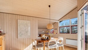 A wooden interior with a dining table, chairs, a hanging light fixture, and a large map on the wall. - "Stefan" - 50m from the sea by Interhome (Odder)