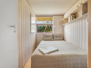 A bedroom with a bed, a window with a view, wooden walls, and a door. - "Stefan" - 50m from the sea by Interhome (Odder)