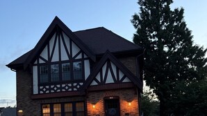 A two-story house with a prominent chimney, a front porch, and a well-maintained lawn. - Walk to the Waves and the Zoo Main St (Racine)