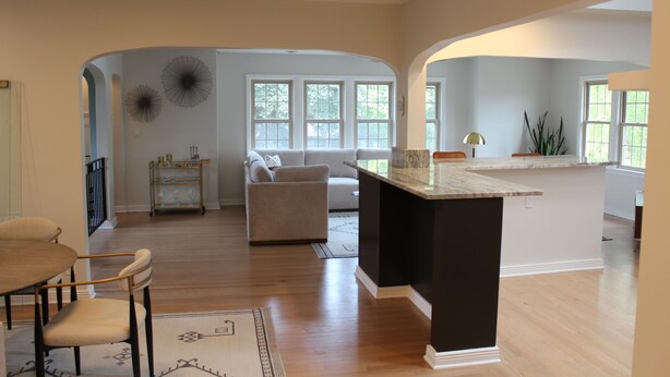 A spacious living area with a kitchen island, a dining table with chairs, and a sofa. - Walk to the Waves and the Zoo Main St (Racine)