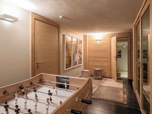 A room with a foosball table, wooden walls, a door, and a small stool. - Chalet Nivicare for 14 pax
Walking distance to ski gondola and village center (Saint-Gervais-les-Bains)