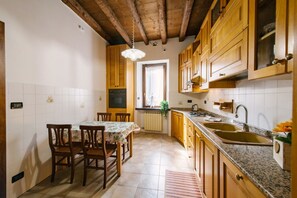 Eine Küche mit Holzausstattung, einer Granitabdeckung und einem Essbereich mit Stühlen und einem Tisch.