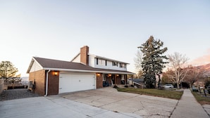 A two-story house with a garage, a covered porch, and a driveway.