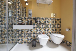 A bathroom with a bidet, toilet, and a mirror. - Malù Bed & Breakfast (Agrigento)