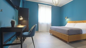 A bedroom with a bed, desk, chair, and a window with curtains. - Malù Bed & Breakfast (Agrigento)