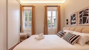 A hotel room with a large bed, two windows with curtains, a sink, and artwork on the wall. - Cocon Heliot hypercentre Toulouse métro A&B Jean Jaurès - Pl. Wilson - Capitole (Toulouse)