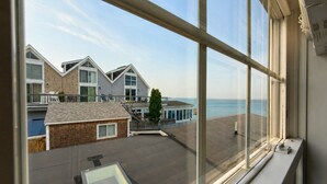 Ein Blick auf einen Küstenkomplex mit mehreren Gebäuden, einer Holzterrasse und freiem Blick auf das Meer.