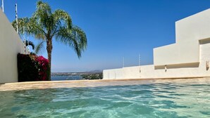A clear swimming pool with a view of the sea and palm trees. - Villa & Pool Cascada - Tequesquitengo Lake View (Tequesquitengo)