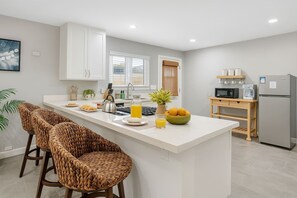 A modern kitchen with a central island, bar stools, a refrigerator, and a microwave. - Two-Private Units/Sleep 9/Pool&Spa/Parking/AC (San Diego)
