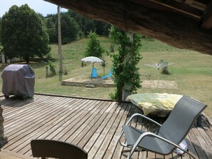 A wooden deck with a covered grill, a covered umbrella, and a lounge chair. - Country house.  Alpes de Haute-Provence (Clumanc)