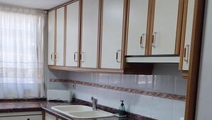 Una cocina con armarios, un lavaplatos y un lavavajillas.