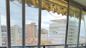 Una habitación con un ventanal grande, una mesa redonda y sillas.