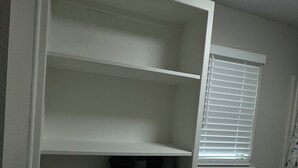A white closet with shelves, a window with blinds, and a carpeted floor. - Home Away From Home II (Amarillo)