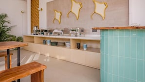 Una cocina moderna con una mesa y banco de madera, una barra con máquinas de café y una pared decorada con siluetas de osos.